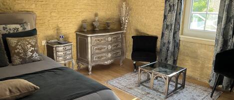 Un dormitorio con cama, cómoda, silla y mesa.