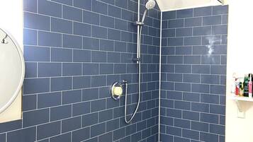 A bathroom with a bathtub, a shower, and a sink.