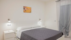 Um quarto com uma cama, mesas de cabeceira e um quadro na parede.