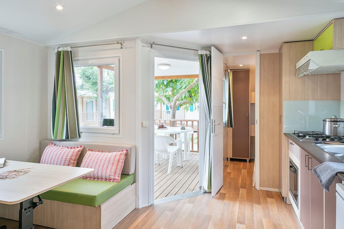 Una cocina compacta con comedor, un pequeño espacio de asiento y vistas al exterior.