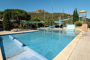 Una piscina con tobogán y una cascada artificial.