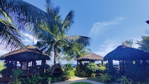 A tropical resort with thatched-roof huts, a well-maintained lawn, and palm trees. - Torre De Alcoy by Hiverooms (Alcoy)