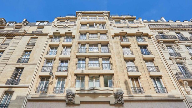 A multi-story building with a classical architectural style, featuring ornate balconies and a symmetrical facade. - Studio Montaigne/ Champs Elysees (Paris)