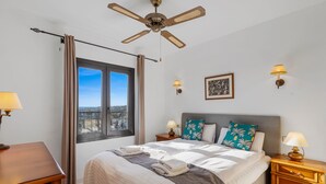 A hotel room with a bed, a desk, a nightstand, a ceiling fan, a window with curtains, and a city view. - Apartment With Roof Terrace and Pool - Ref 129 (Mijas)