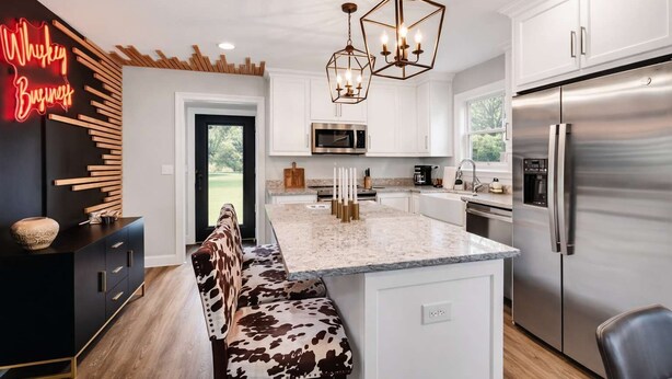 A modern kitchen with a central island, stainless steel appliances, and a neon sign. - Modern rustic home near Bardstown top distilleries (Bardstown)