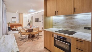 Une cuisine moderne avec des meubles en bois, un four encastré et un plan de travail en marbre.
