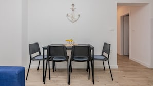 A dining area with a round table, four chairs, and a wall-mounted anchor decoration. - 1 bedroom cozy apartment in Vir (Vir)