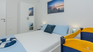 A hotel room with a bed, a chair, a desk, and a nightstand. - 1 bedroom cozy apartment in Vir (Vir)