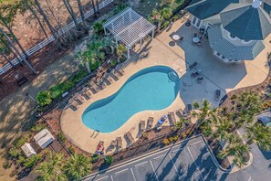 Relax by the oval-shaped pool surrounded by lounge areas and shaded seating options.