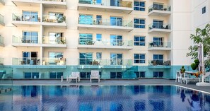 A modern hotel with a rooftop pool, multiple balconies, and glass railings. - Charming 1 BR in AG Tower - Canal Views (Dubai)