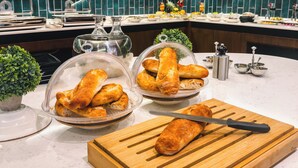Un piano di lavoro in cucina con pane, un tagliere e un coltello.