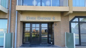 A building with a sign reading 'Den Oever 4' and a glass entrance.