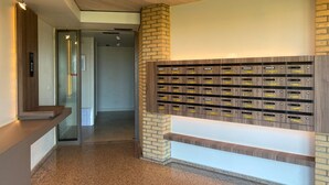 A reception area with a wooden reception desk, a wall-mounted mailbox system, and a glass door leading to another room.