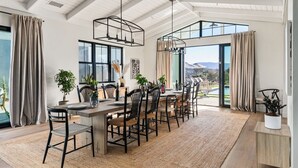 A spacious dining area with a high ceiling, large windows, and a view of the outdoors. - Vintner's Village | California-Chic Wine Estate (Temecula)