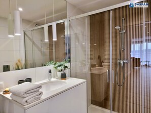 Departamento Confort, vista al jardín | Baño | Regadera, secadora de cabello, toallas, papel de baño 