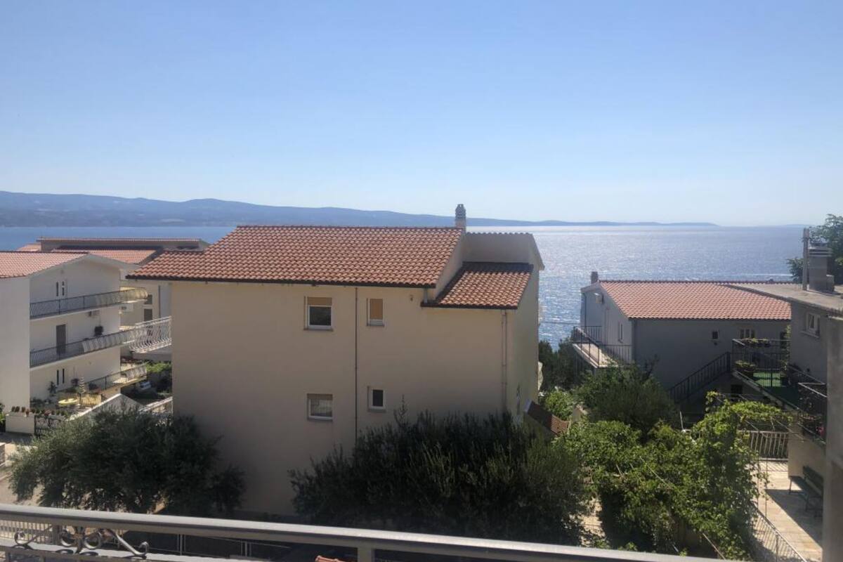 Un quartier résidentiel situé sur la côte, caractérisé par des bâtiments aux toits recouverts de tuiles rouges et dotés de balcons.