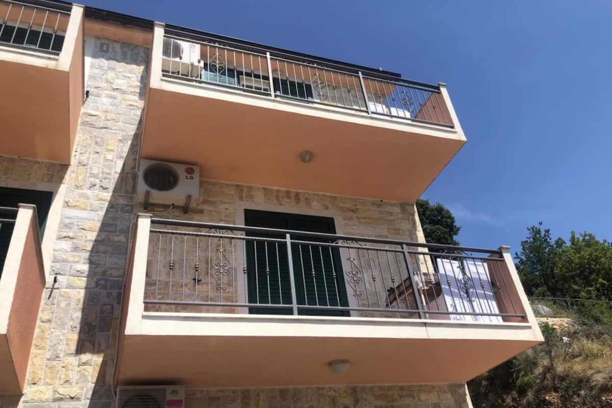 Un immeuble à plusieurs étages doté de balcons, d’une façade en pierre et d’un appareil de climatisation.