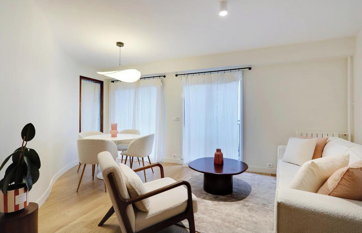 Un salon moderne avec une table basse ronde, un canapé et un coin repas comprenant des chaises et une table.