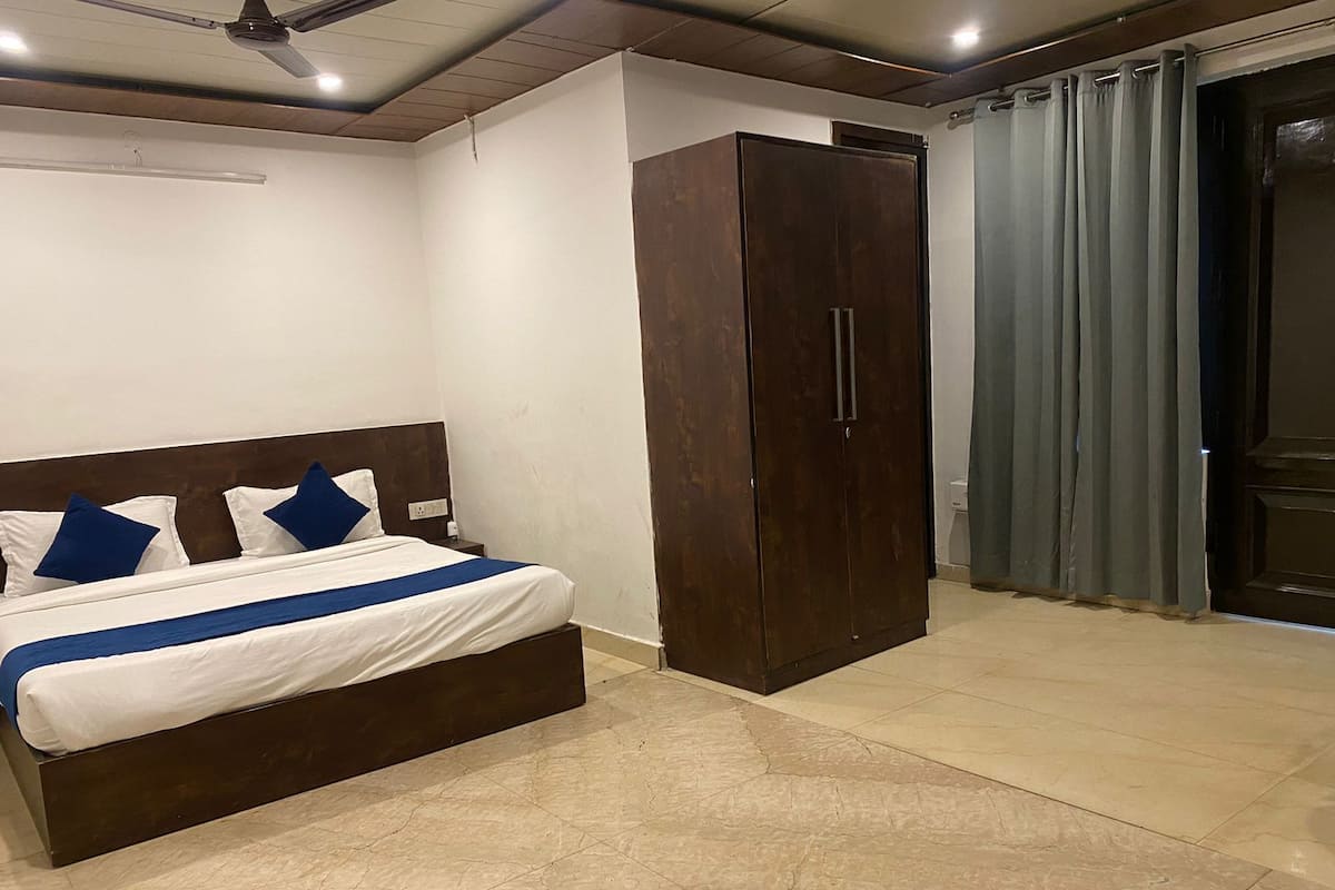 A bedroom with a bed, a wardrobe, and a bathroom door.