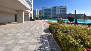 Een modern gebouw met een zwembad, verhard pad en aangelegde tuin.