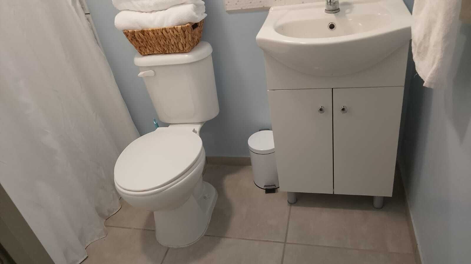 Et badeværelse med toilet, vask og skab.