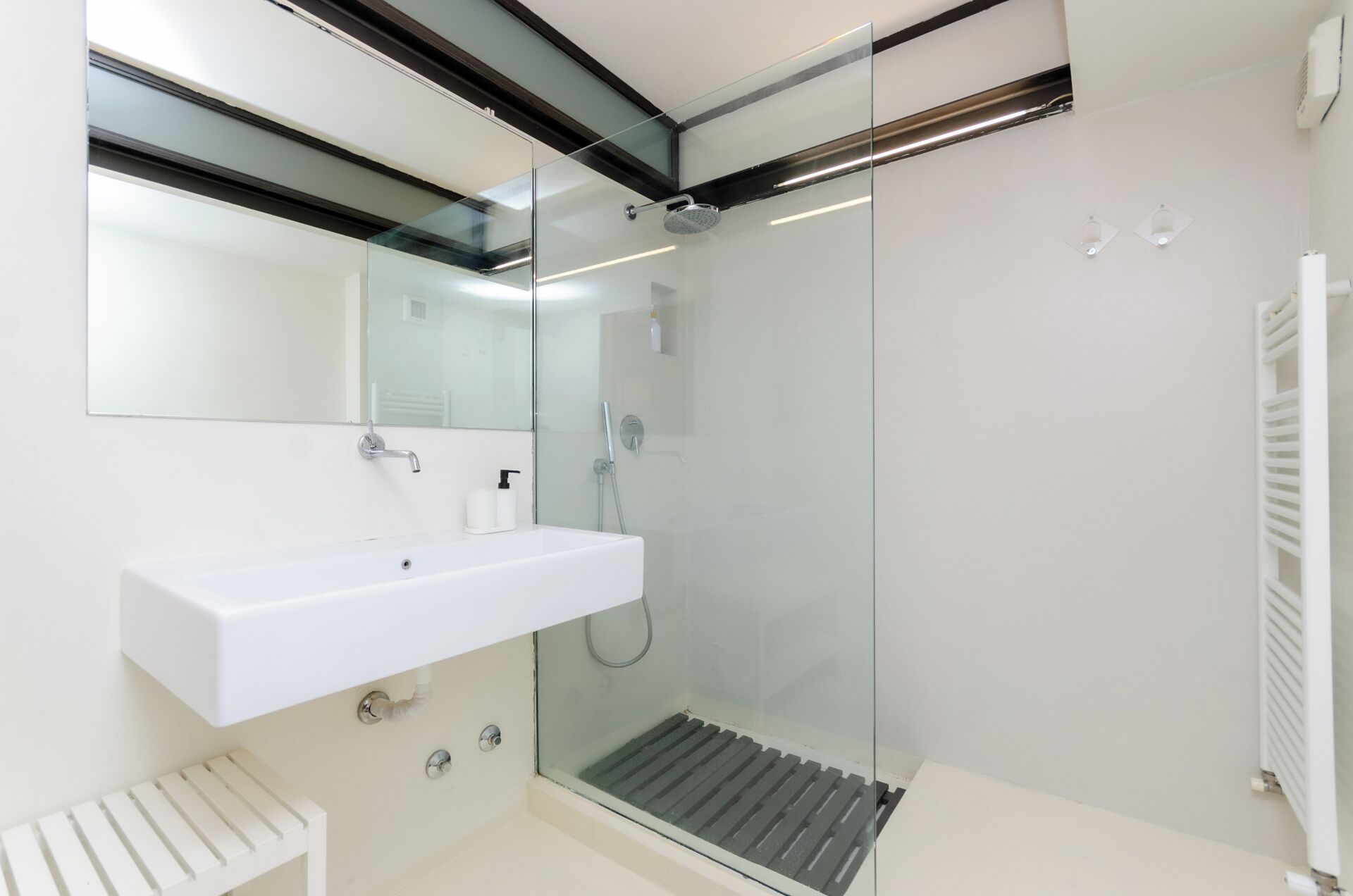Une salle de bain moderne avec une douche à parois de verre, un lavabo blanc et des toilettes blanches.