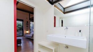 A modern bathroom with a white sink, a mirror, and a bench. - VivimiHome-Esclusivo loft con terrazzo (Milan)