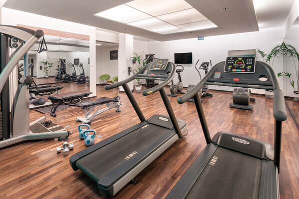 A gym with treadmills, weight machines, and free weights.