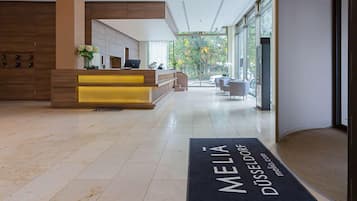 Una moderna zona de recepción con mostrador, asientos y vistas al exterior.