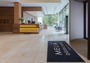 Una moderna zona de recepción con mostrador, asientos y vistas al exterior.