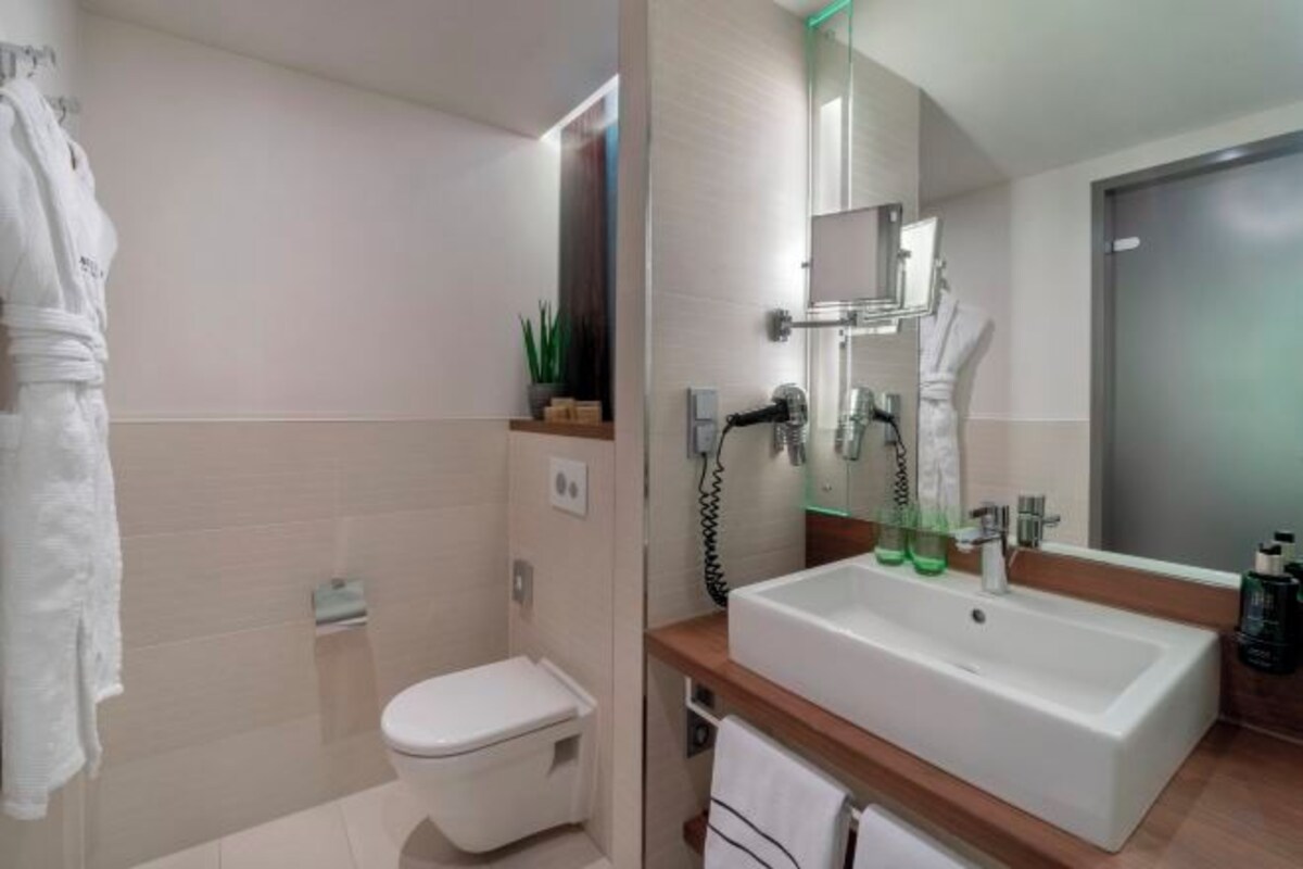 Une salle de bain moderne équipée de toilettes, d’un lavabo et d’une douche.