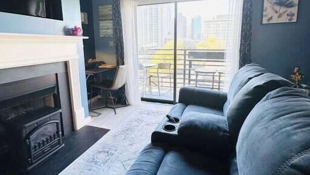 A living room with a sofa, a fireplace, and a view of the outdoors. - Your home away from home - Weekly (Charlotte)