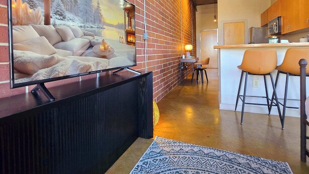 Een moderne woonkamer met een grote flatscreen-tv, een open haard en een gezellige zithoek.