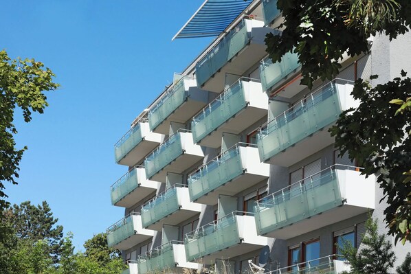 A multi-story building with balconies, a satellite dish, and a clear blue sky. - smal-Apartment (Ostfildern)