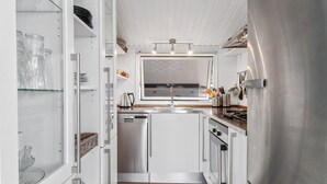 A compact kitchen with a built-in dishwasher, a stainless steel refrigerator, and a checkered floor. - 2 bedroom stunning home in Vinderup (Vinderup)