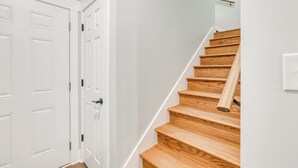A staircase with wooden steps and white walls. - 7 Mi to Talladega Superspeedway: Home w/ Lake View (Lincoln)