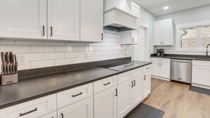 A modern kitchen with white cabinets, a granite countertop, and stainless steel appliances. - 7 Mi to Talladega Superspeedway: Home w/ Lake View (Lincoln)
