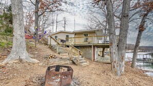 Ein zweistöckiges Haus mit einer Holzterrasse und einer Treppe, die zu der oberen Etage führt.
