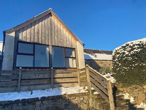 Cozy cabin-style building with a steeply pitched roof and large windows, perfect for a traditional alpine retreat.