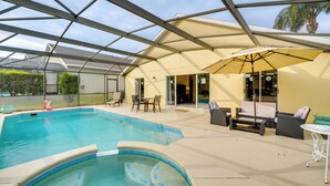 Een overdekt buitenzwembad met lounge meubilair en een terras.