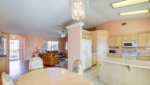 A spacious kitchen with a central island, a dining area with a round table, and a living room with a sofa and chairs. - Hike, Boat, Golf & Unwind: Lake Havasu City Home! (Lake Havasu City)