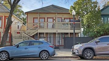 A two-story building with a balcony, a staircase, and a gated entrance.