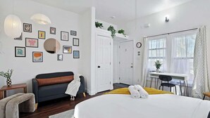 Una moderna camera d'albergo con un letto grande, una poltrona, una scrivania e un'area pranzo.
