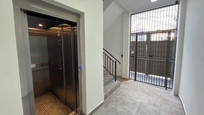 An elevator with a metallic interior and a textured floor. - CONDOMÍNIO RESIDENCIAL VITÓRIA 3 (São Paulo)