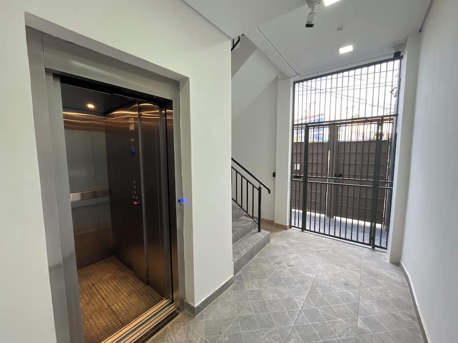 An elevator with a metallic interior and a textured floor.
