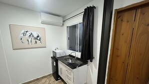 A compact kitchen with a window, a sink, and a cabinet. - CONDOMÍNIO RESIDENCIAL VITÓRIA 3 (São Paulo)