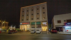 A multi-story building with a reception area and signage indicating a hotel. - أحلى الليالي للشقق الفندقية Ahla Al Layali Hotel Apartments (Yanbu)