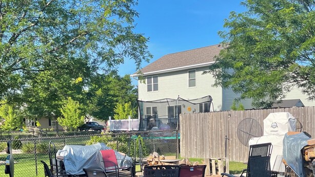 A backyard with a fire pit, outdoor furniture, and a grill.