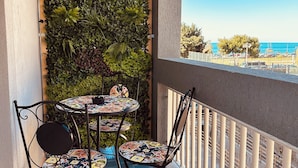 Ein Balkon mit Fliesenboden, einer Holz-Pergola und einer mit Grünpflanzen bewachsenen Wand.