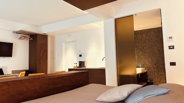 Ein modernes Hotelzimmer mit Bett, Schreibtisch und Bad.